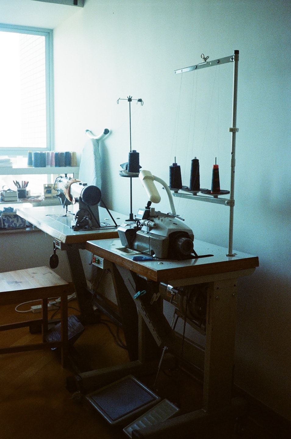 Dos máquinas de coser industriales listas para usarse en un taller luminoso.
