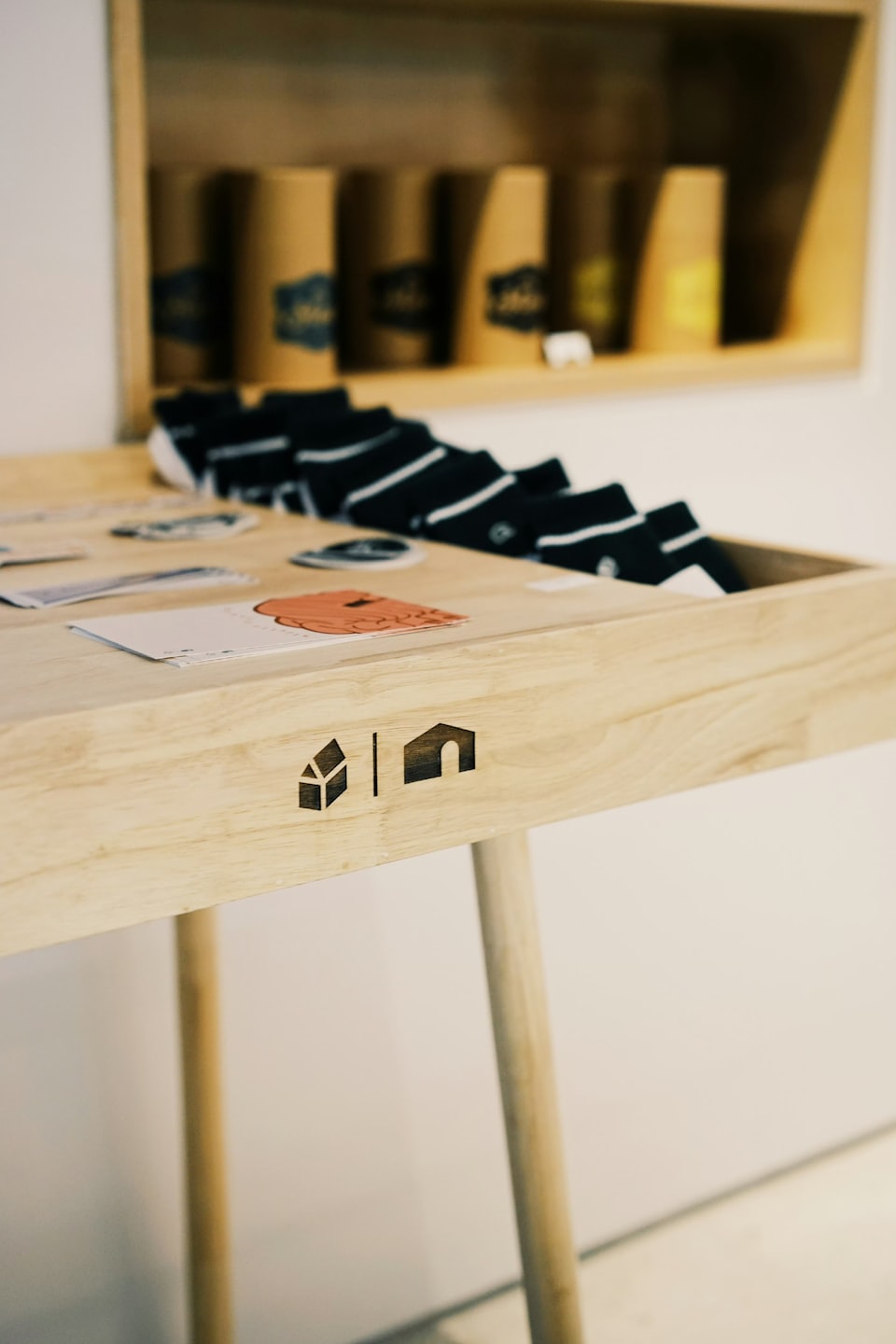 Calcetines a rayas y tarjetas expuestos en una mesa de madera de una tienda.